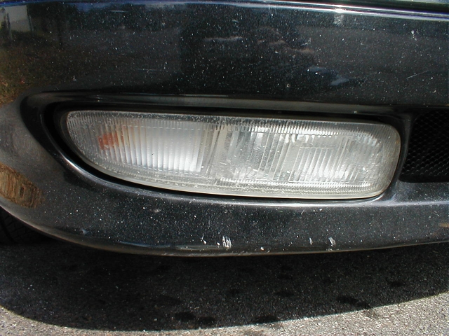 Yellowed fog light before...
(Notice there is a lot of plastic shavings in there from drilling out the holes for the parking lights)